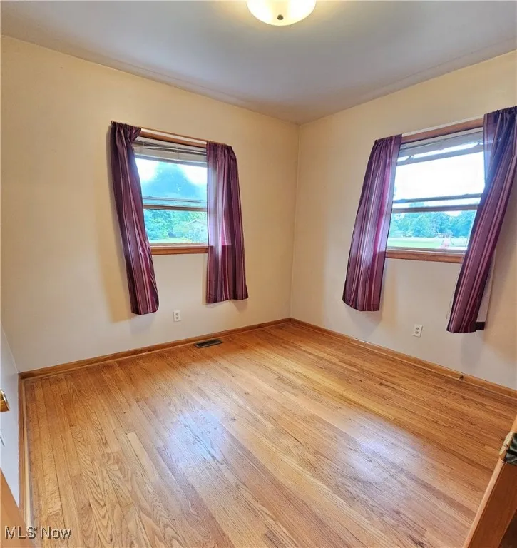 Unfurnished room with hardwood floors
