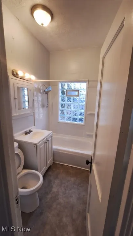Full bathroom featuring vanity, shower / bathtub combination, and a textured ceiling