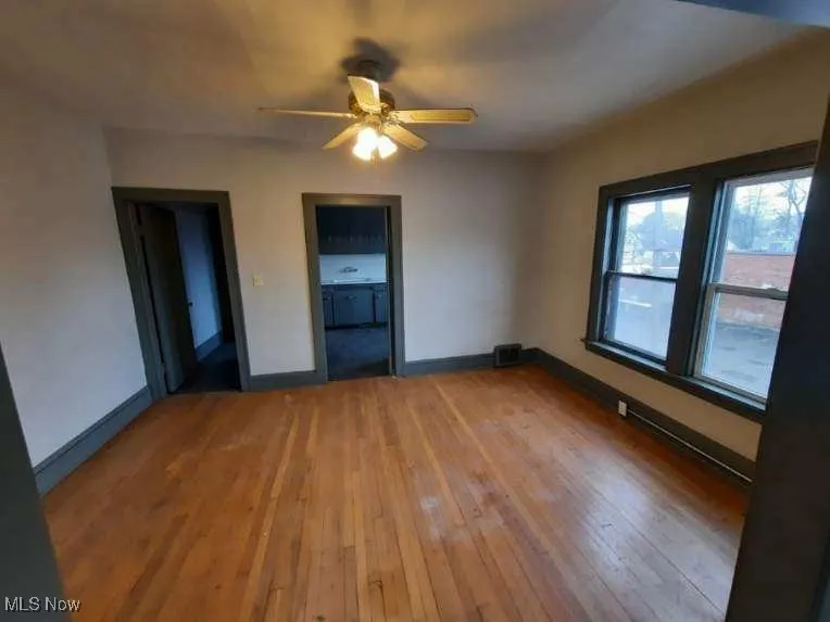 Spare room with light wood-type flooring and ceiling fan