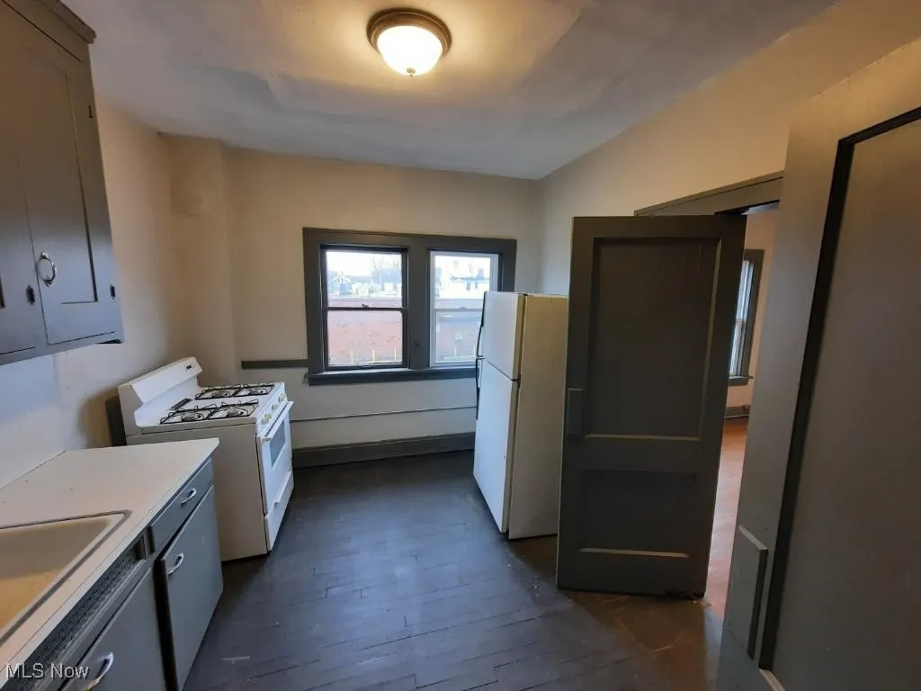 Kitchen with white appliances, light countertops, and dark wood finished floors