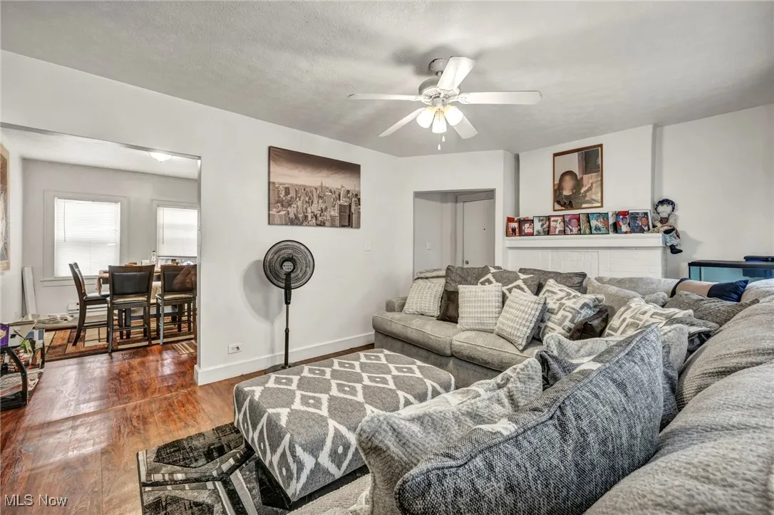 Living room with wood finished floors, a ceiling fan, and a textured ceiling