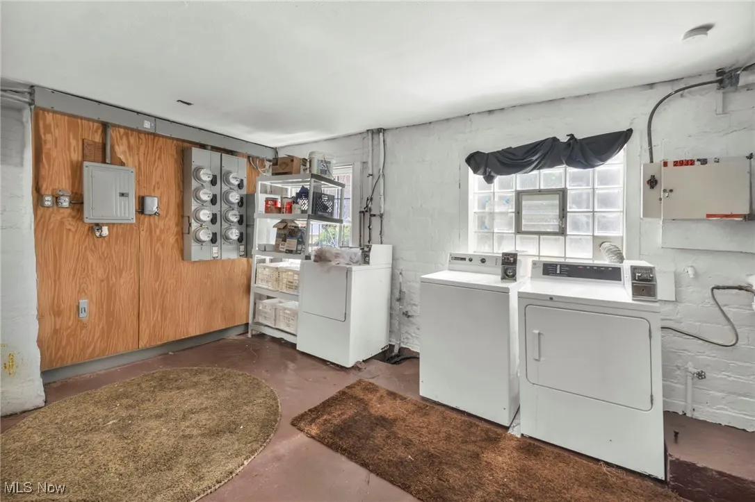 Washroom with washing machine and clothes dryer and electric panel