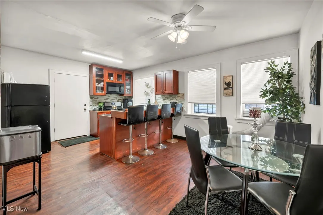 Dining area featuring dark wood-style flooring and ceiling fan