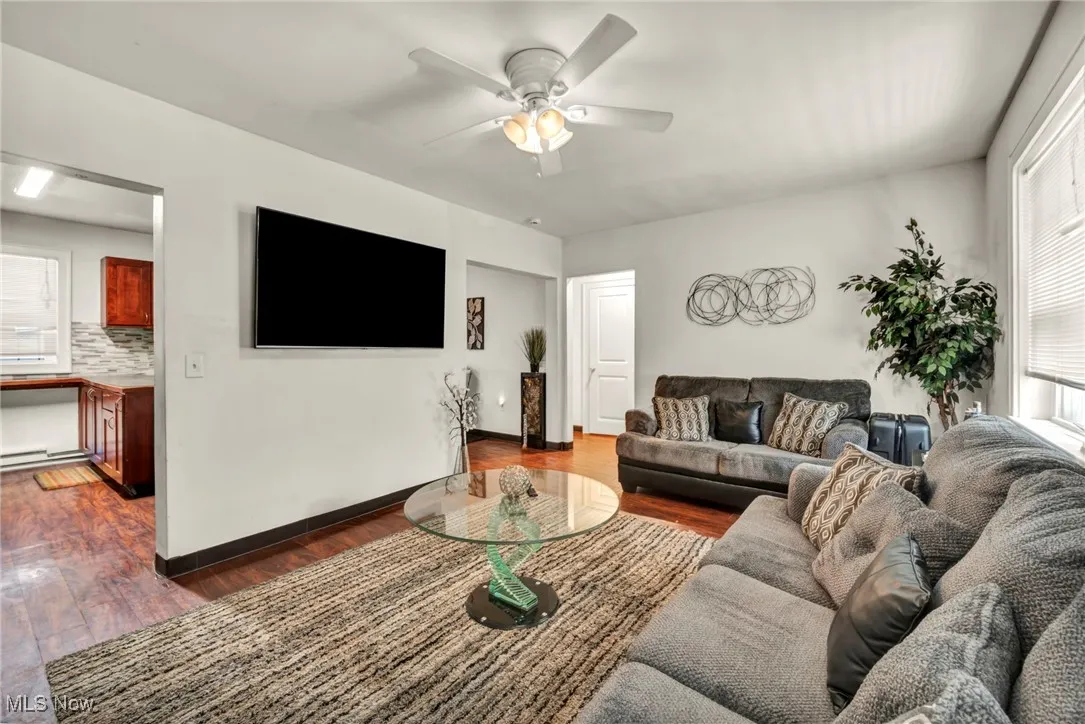 Living area with dark wood-style flooring and ceiling fan