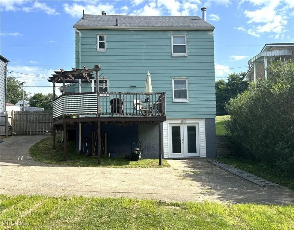 Back view of home with a deck, a pergola, and french doors