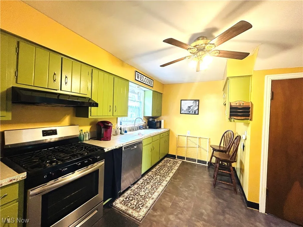 Kitchen with appliances, and green cabinetry