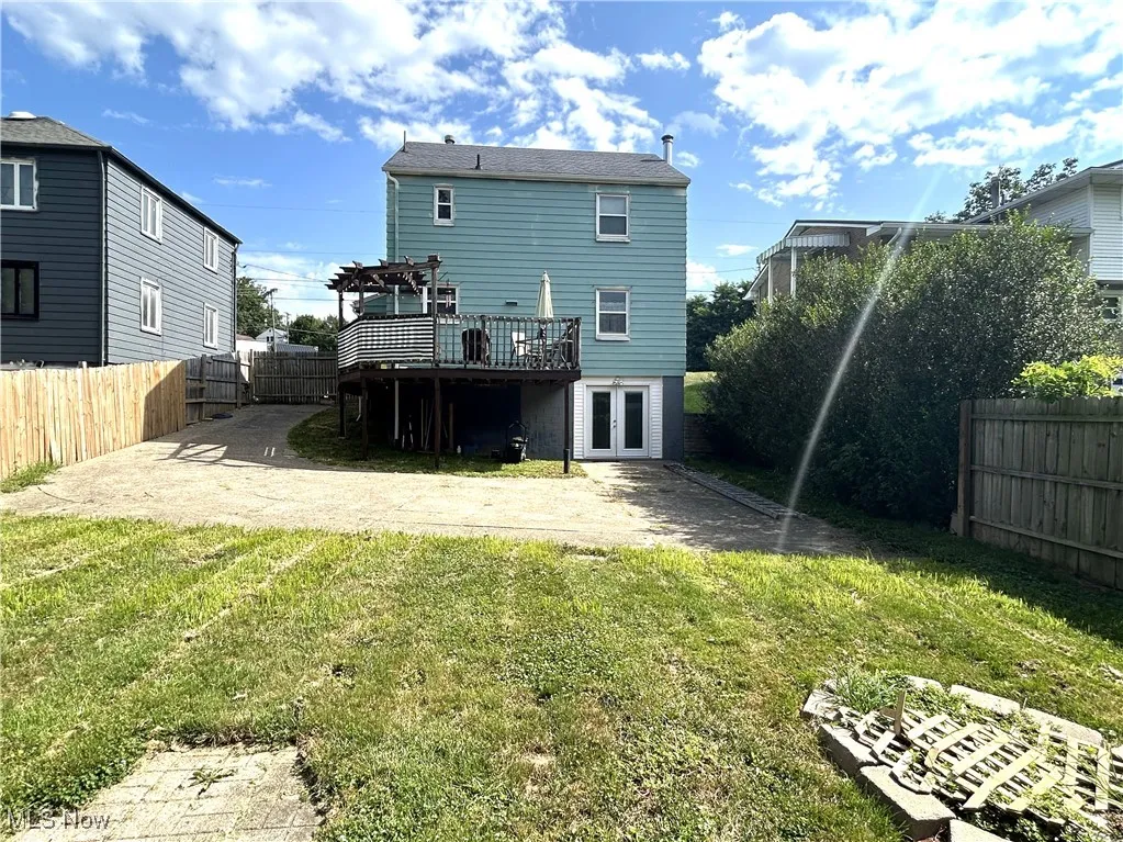 Back of house featuring french doors, a pergola, a fenced backyard, and a deck