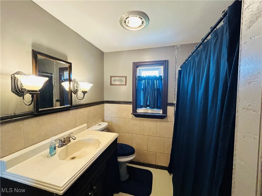 Bathroom with vanity, toilet and a shower