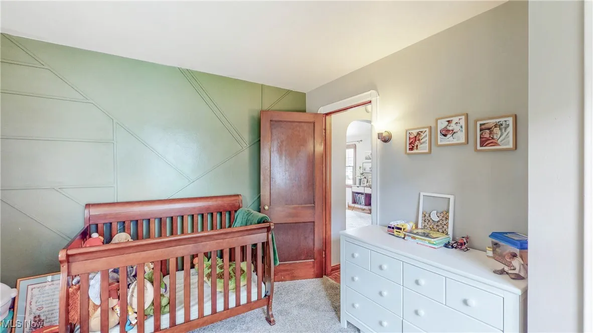 Carpeted bedroom with arched walkways