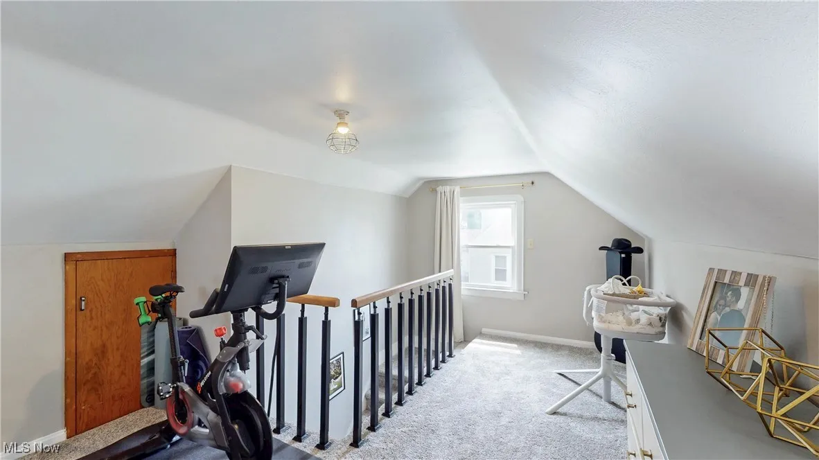 Office area with vaulted ceiling and carpet