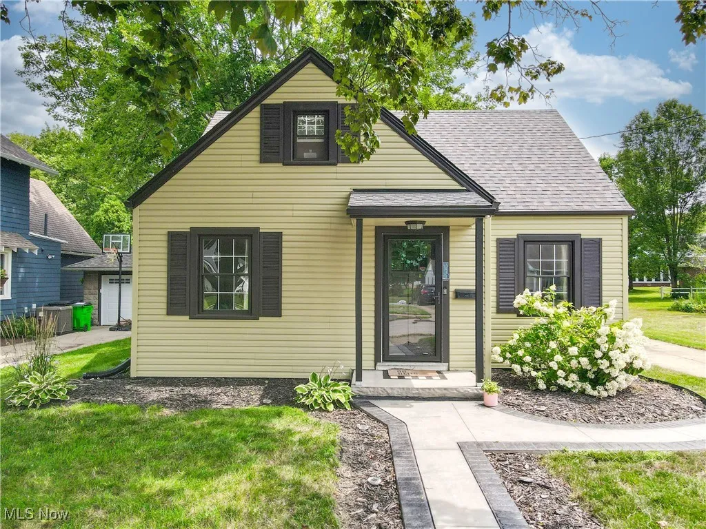 View of front of house with a shingled roof and a front yard