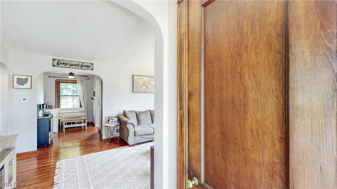 Hall with arched walkways and wood finished floors