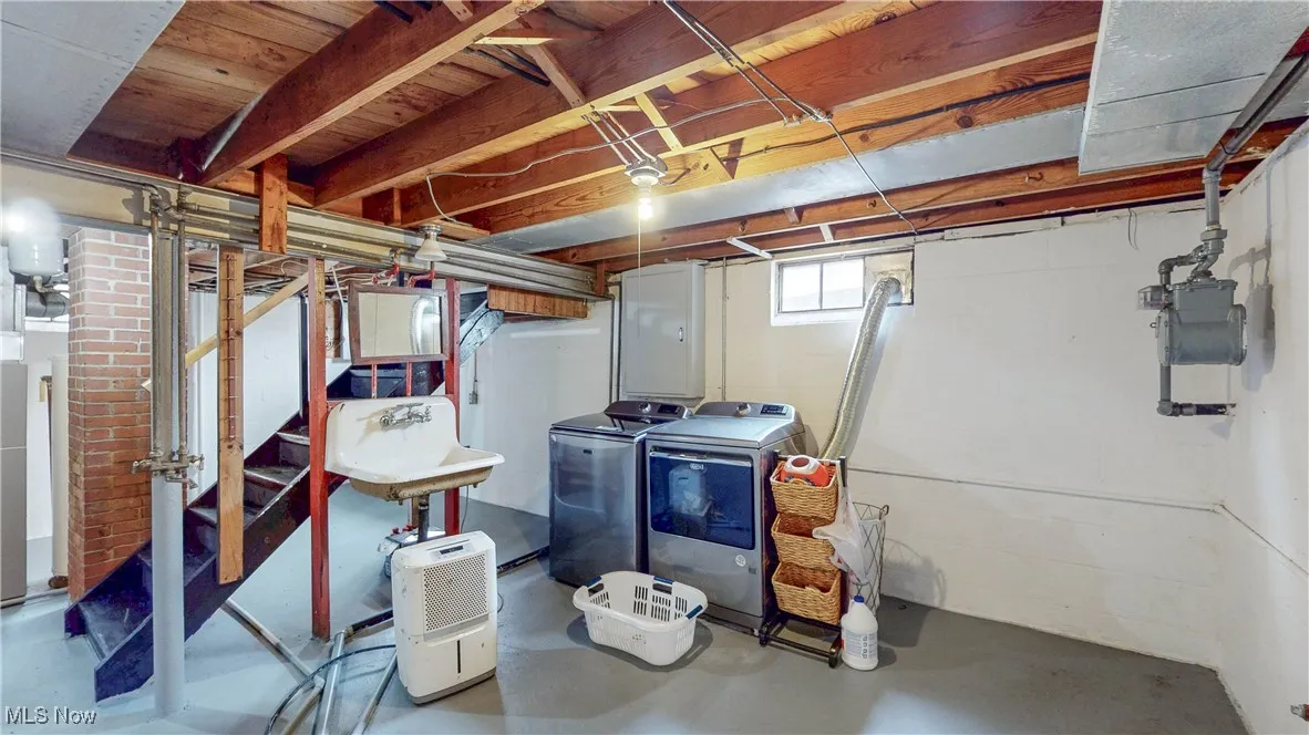 Basement with separate washer and dryer and stairway