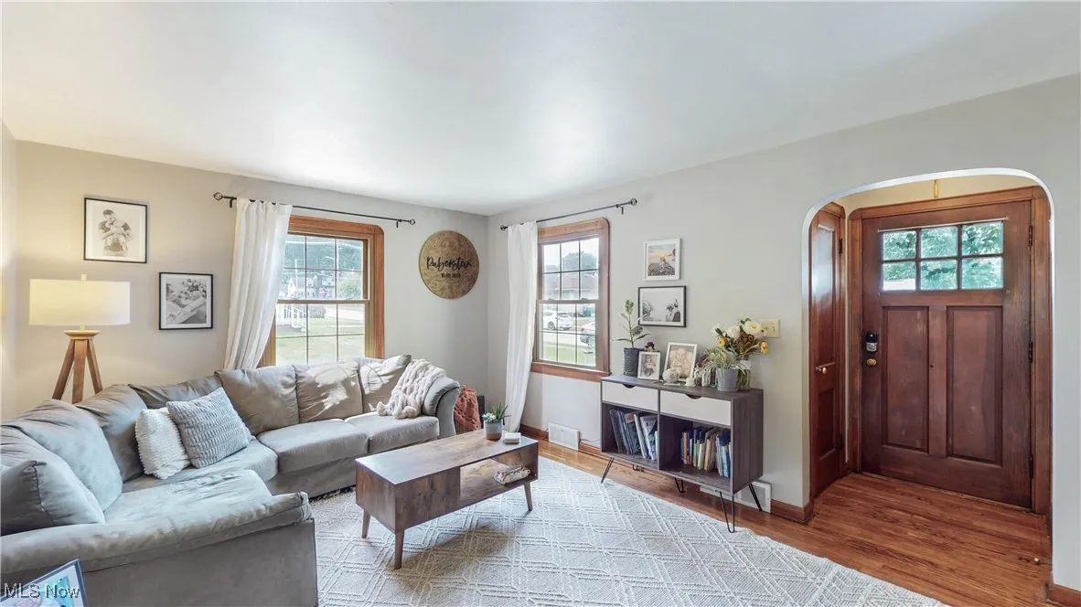 Living room with wood finished floors, plenty of natural light, and arched walkways