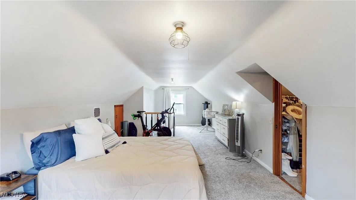 Bedroom featuring carpet floors and lofted ceiling