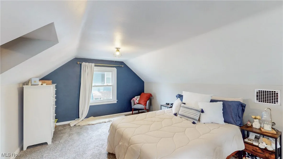 Bedroom with carpet and lofted ceiling