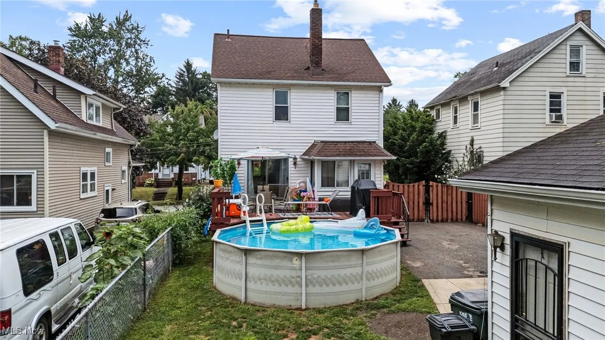 Back of house featuring a chimney, a gate, and a fenced backyard
