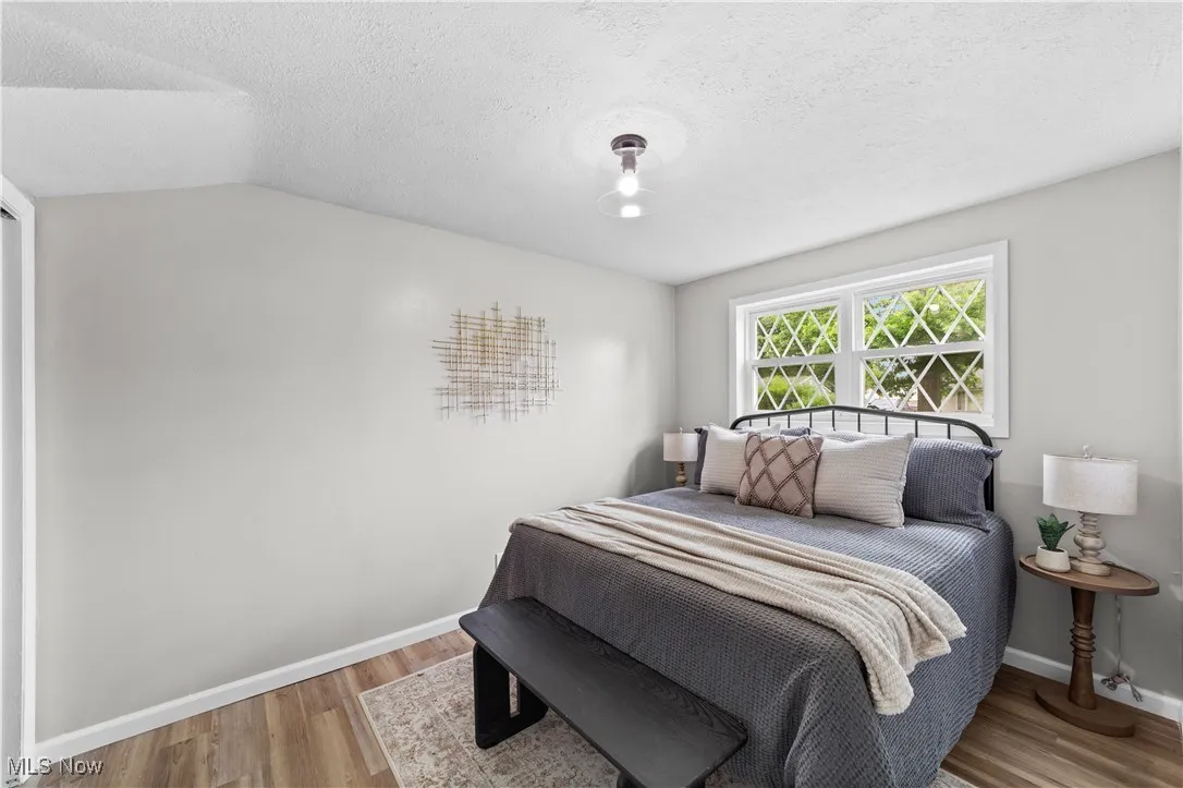Bedroom with wood finished floors and a textured ceiling