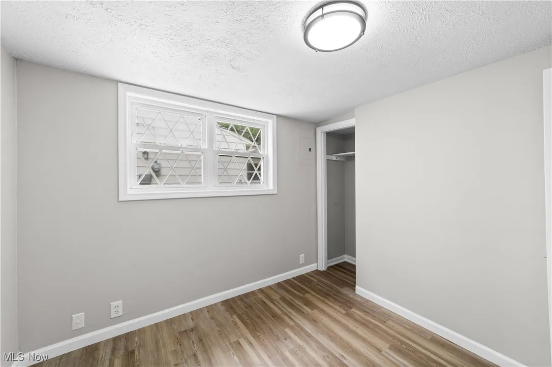 Unfurnished bedroom with wood finished floors, a textured ceiling, and a closet