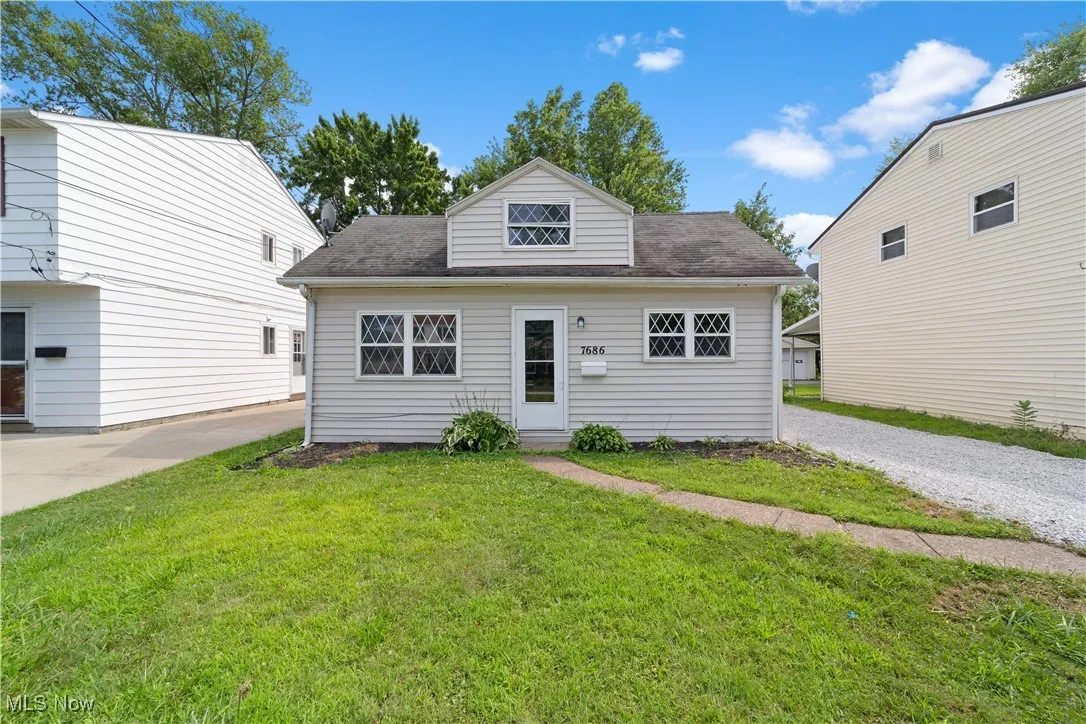 Bungalow-style house with a front yard, a shingled roof, and driveway