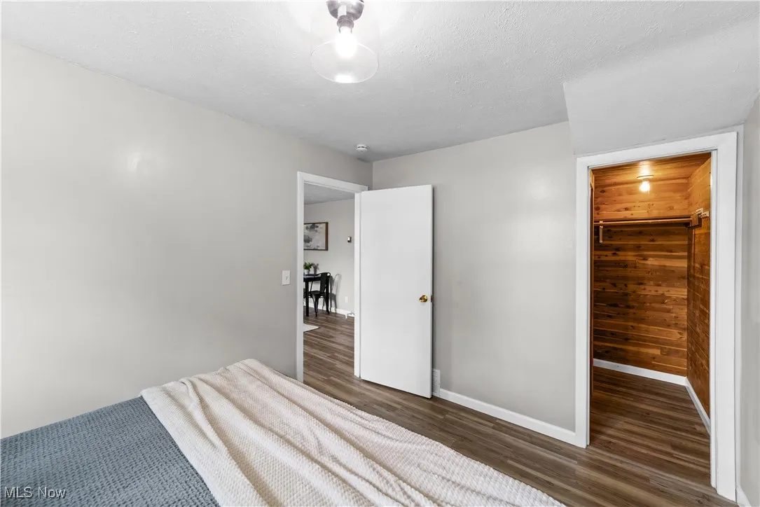 Unfurnished bedroom with wood finished floors and baseboards