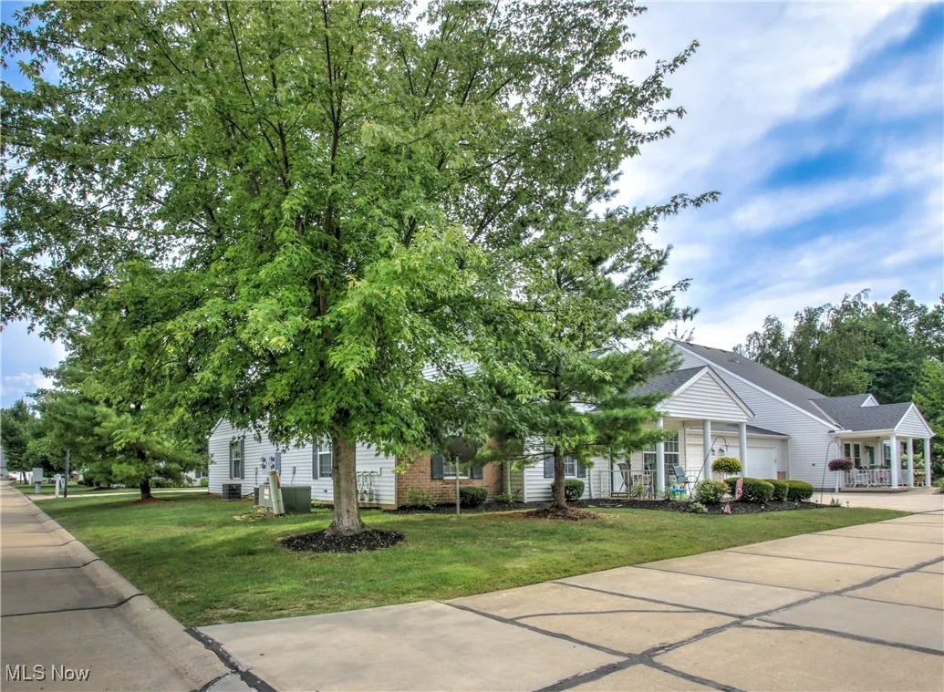 View of front facade featuring a front yard, driveway, and brick siding