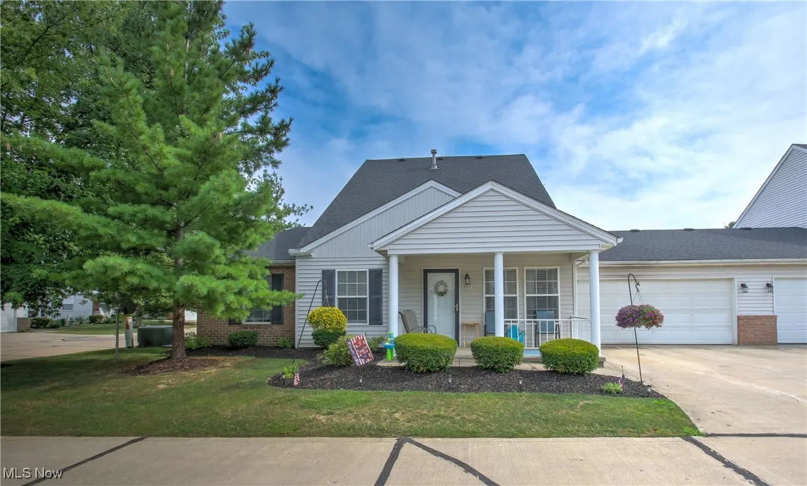 Bungalow-style house featuring a porch, a front lawn, concrete driveway, and a shingled roof