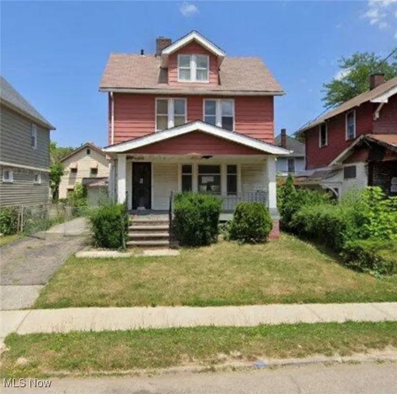 American foursquare style home with a porch and a front lawn