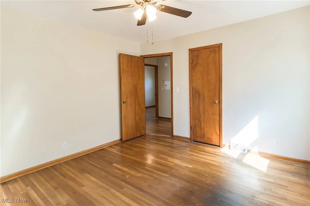Unfurnished bedroom with wood finished floors and a ceiling fan
