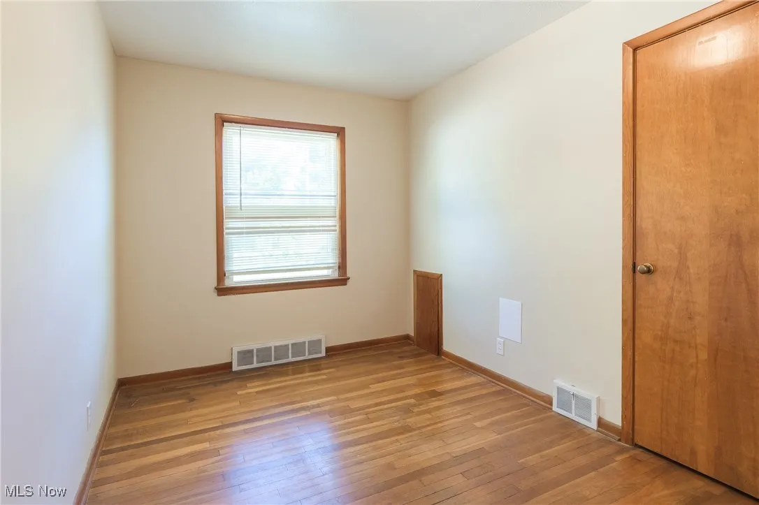 Spare room with light wood-style floors and baseboards