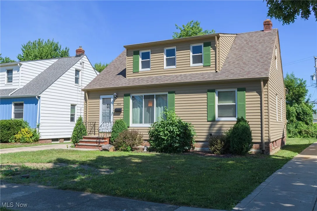 View of front of home featuring a front lawn, a shingled roof, a chimney, and crawl space
