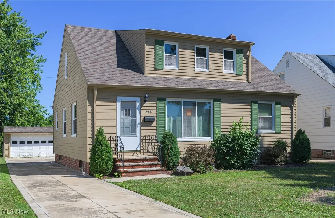Bungalow with an outdoor structure, a front lawn, a chimney, roof with shingles, and a garage
