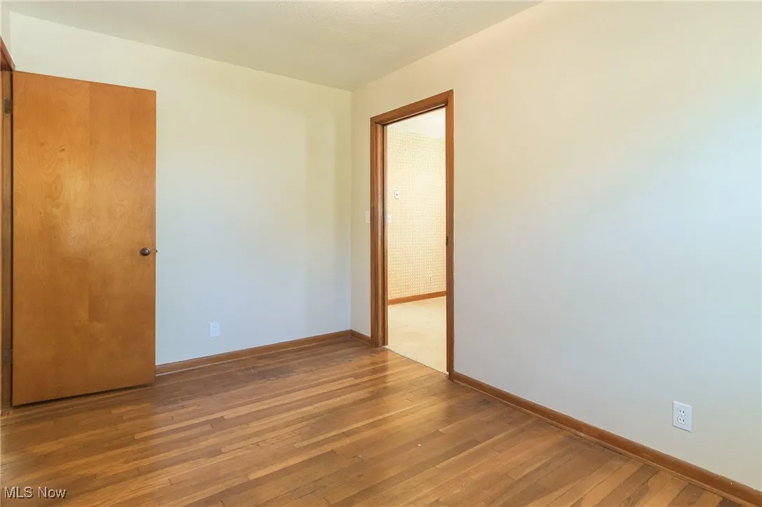 Unfurnished room featuring baseboards and wood-type flooring