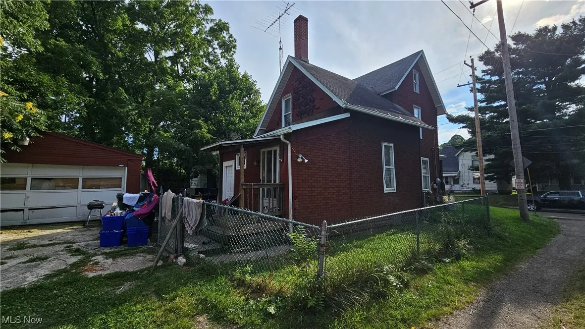 View of front of house featuring covered porch, a front yard, and brick siding