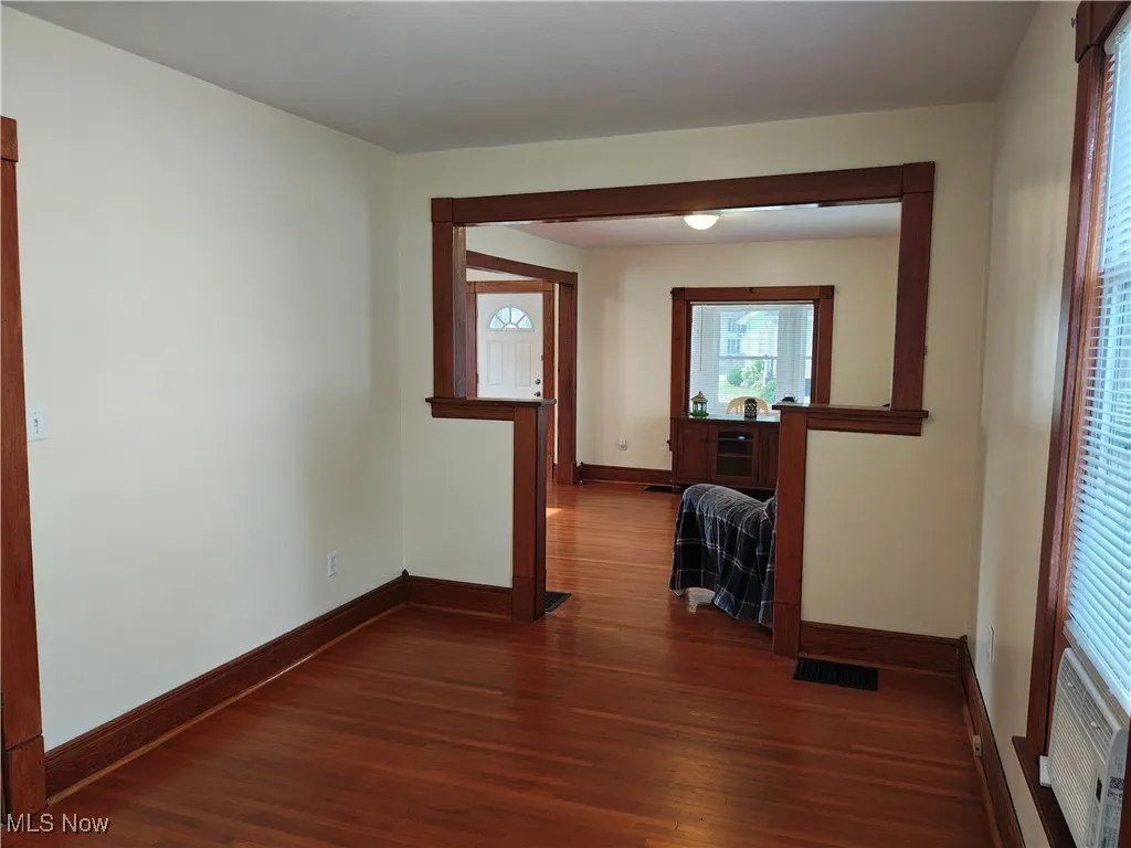 Hall featuring dark wood finished floors and baseboards