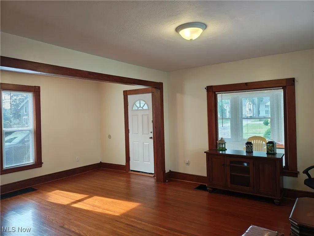 Entryway featuring dark wood-style flooring and baseboards