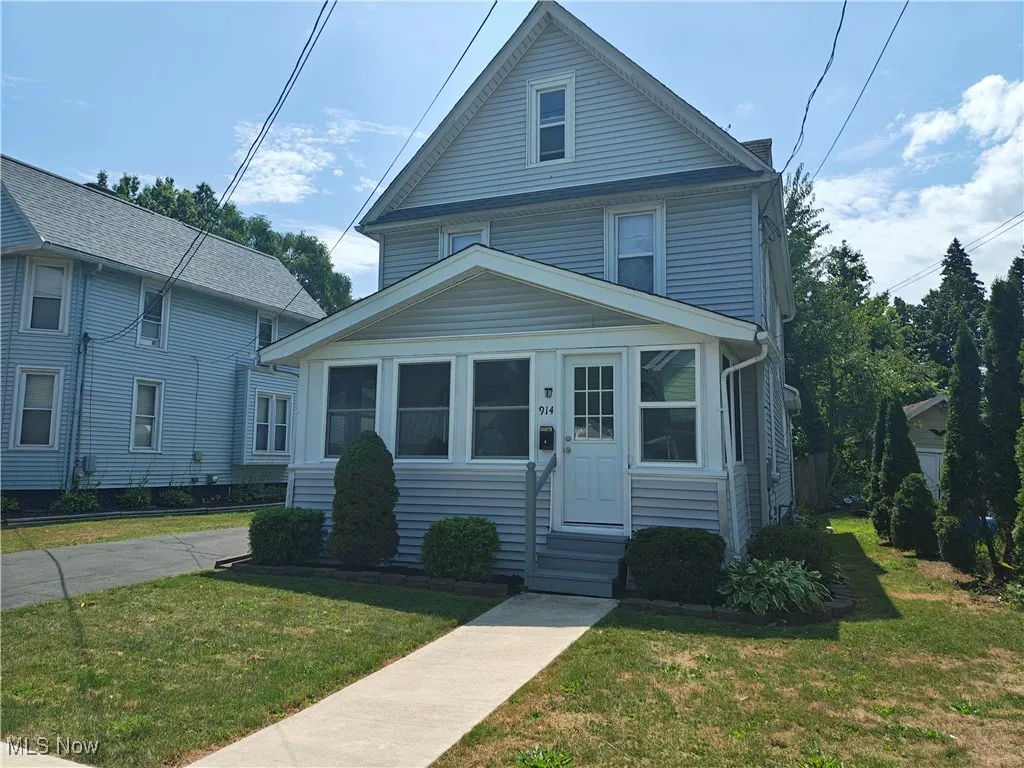 American foursquare style home with entry steps and a front lawn