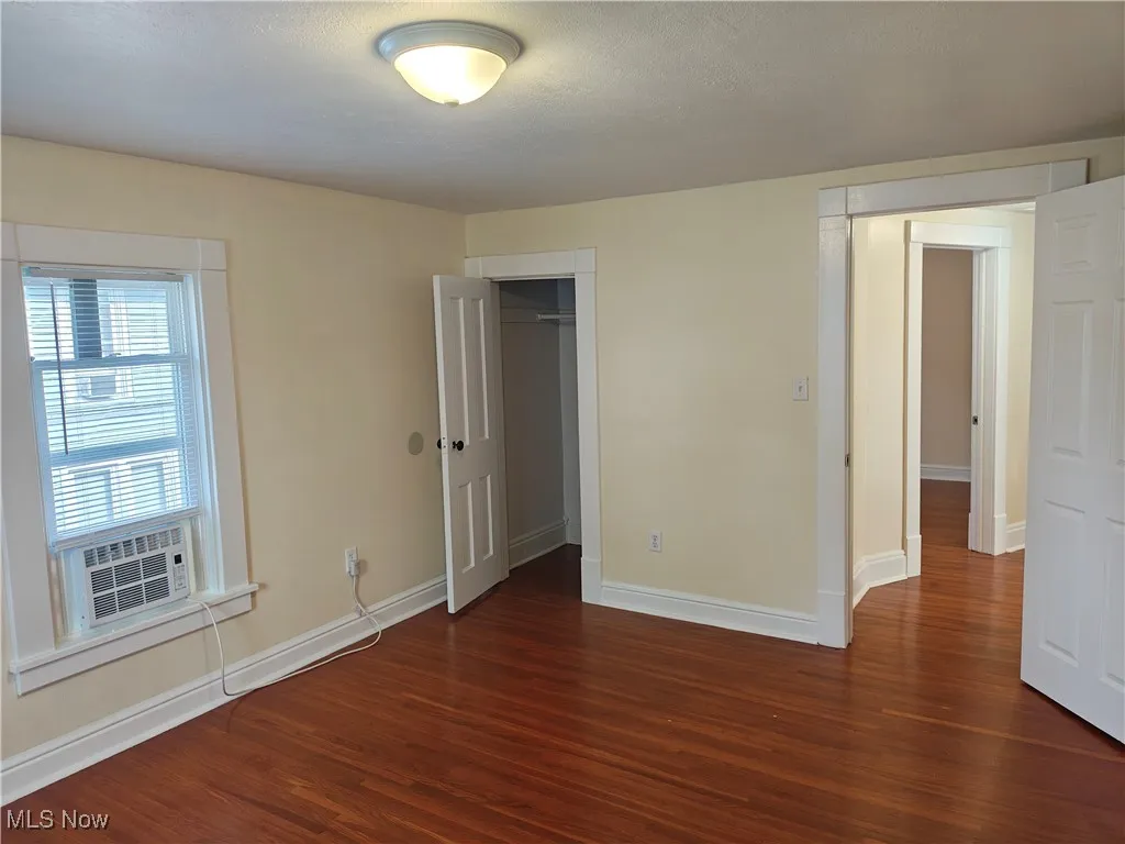 Unfurnished bedroom with wood finished floors and a closet