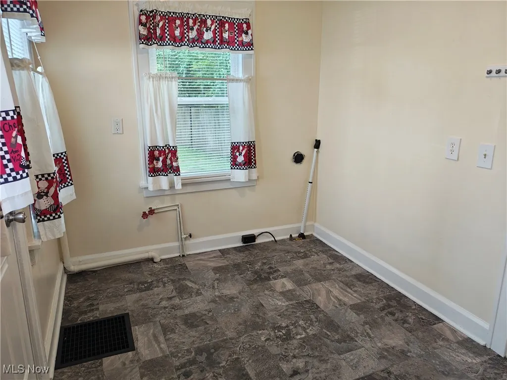 Laundry room featuring baseboards and stone finish flooring