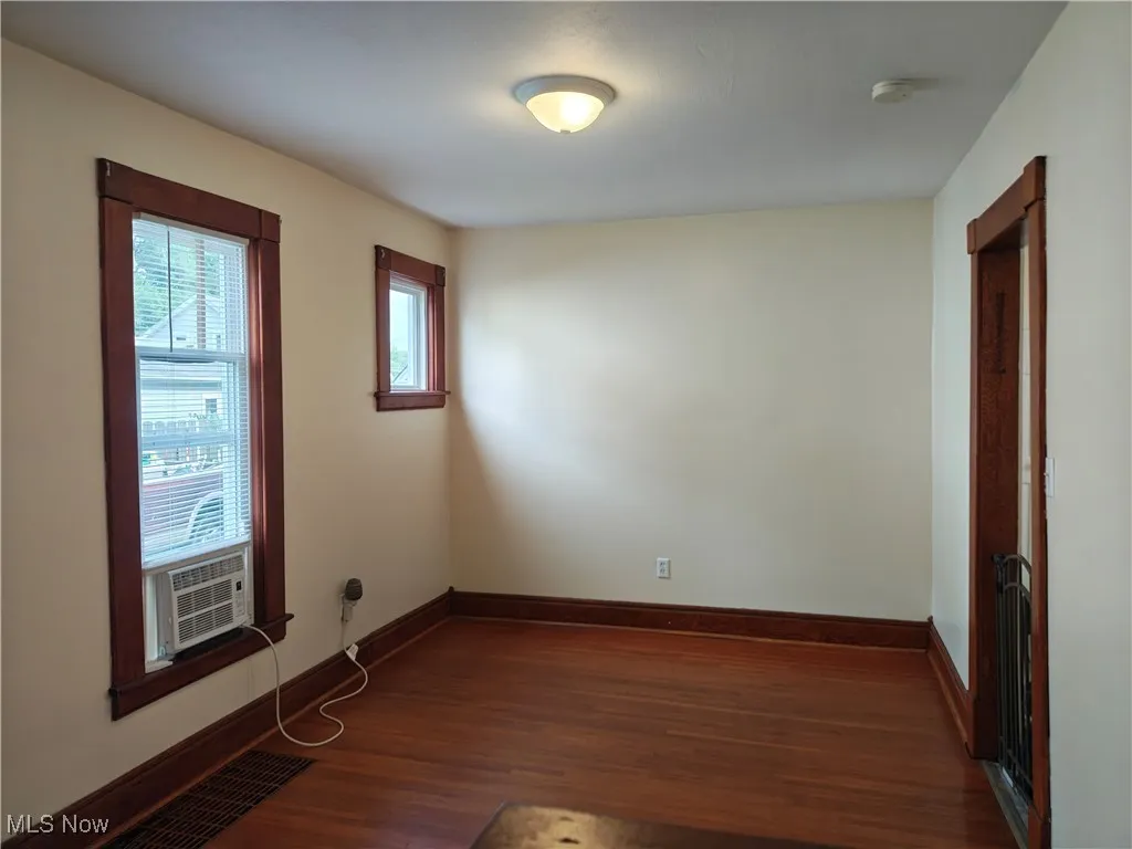 Unfurnished room featuring dark wood-style flooring and cooling unit