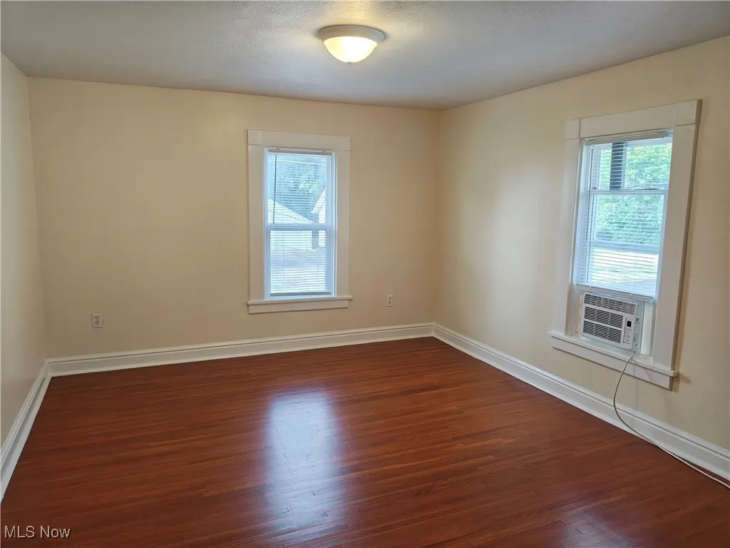 Unfurnished room with dark wood-type flooring and cooling unit