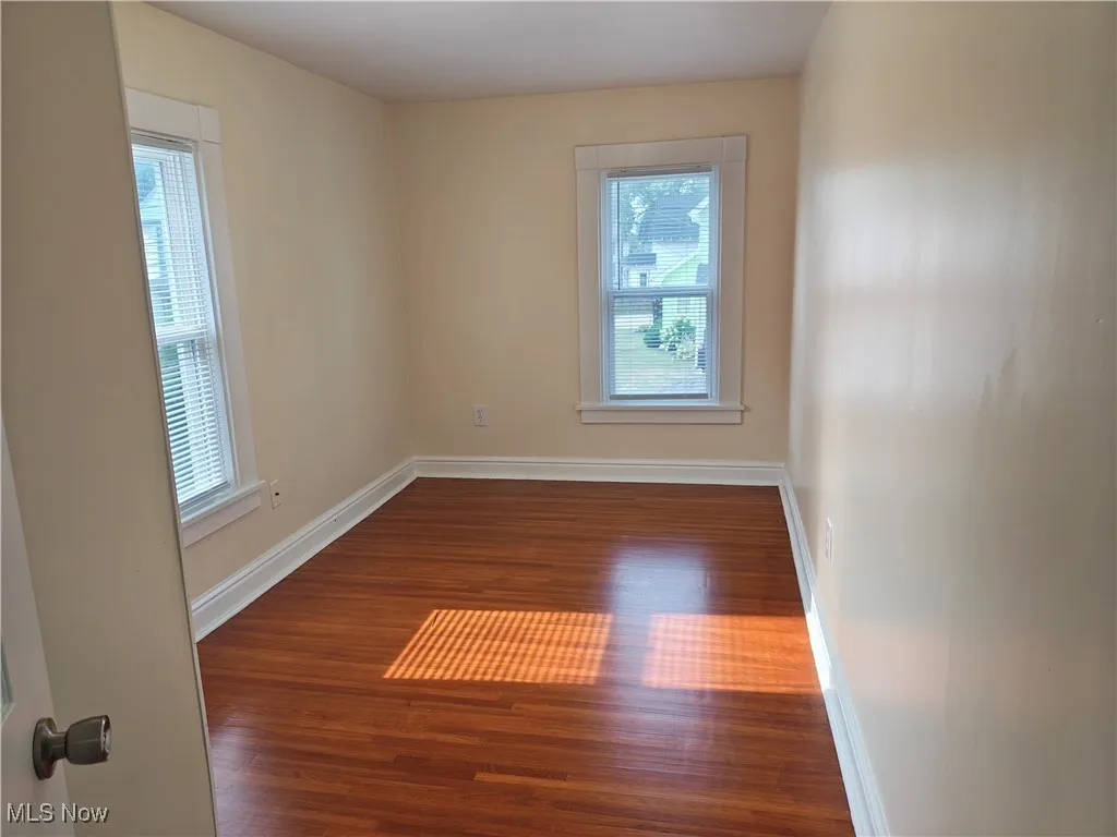 Spare room featuring baseboards and wood finished floors