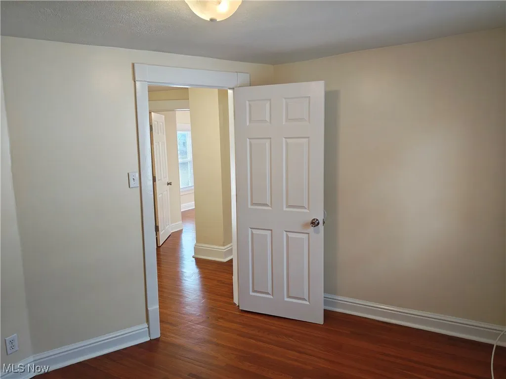 Unfurnished room with dark wood finished floors and a textured ceiling