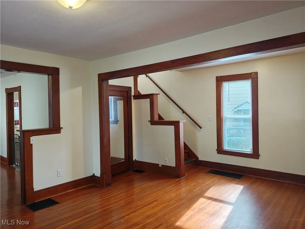 Empty room featuring stairway and wood finished floors