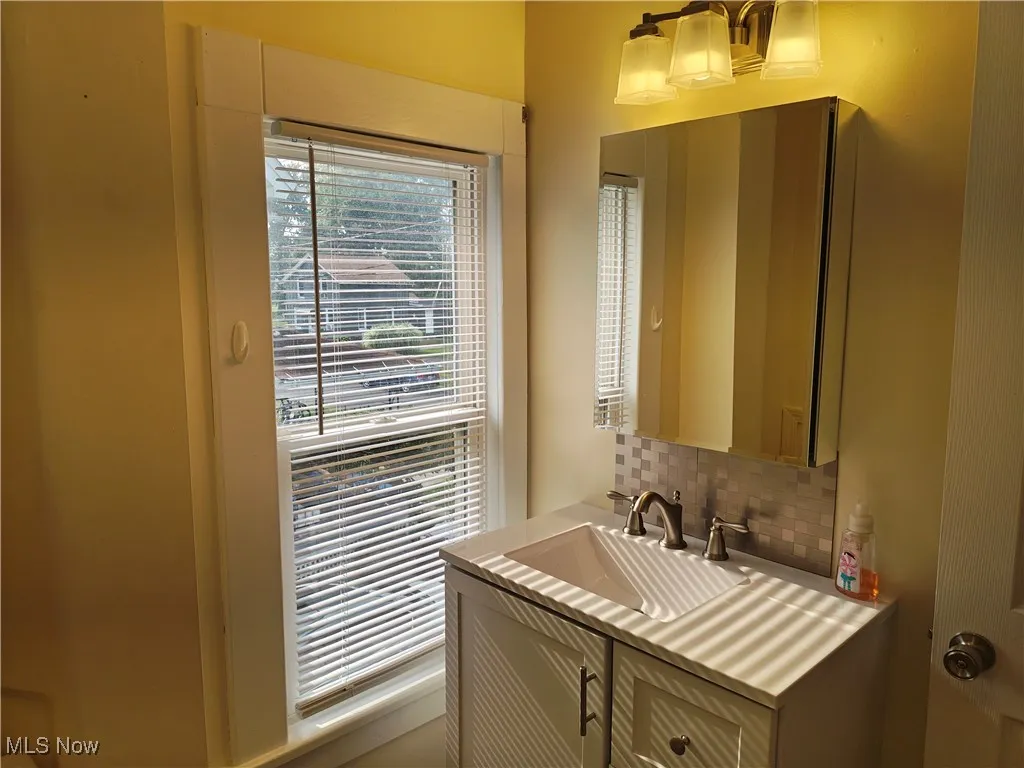 Bathroom with tasteful backsplash and vanity