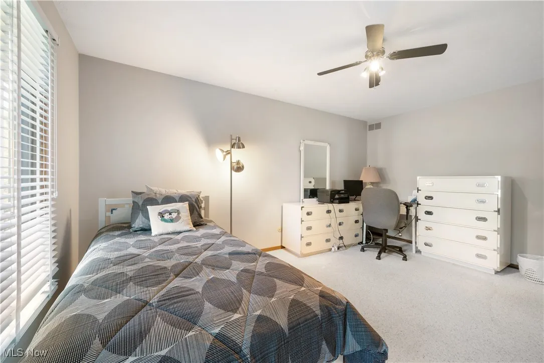 Bedroom featuring carpet flooring, an office area, and a ceiling fan