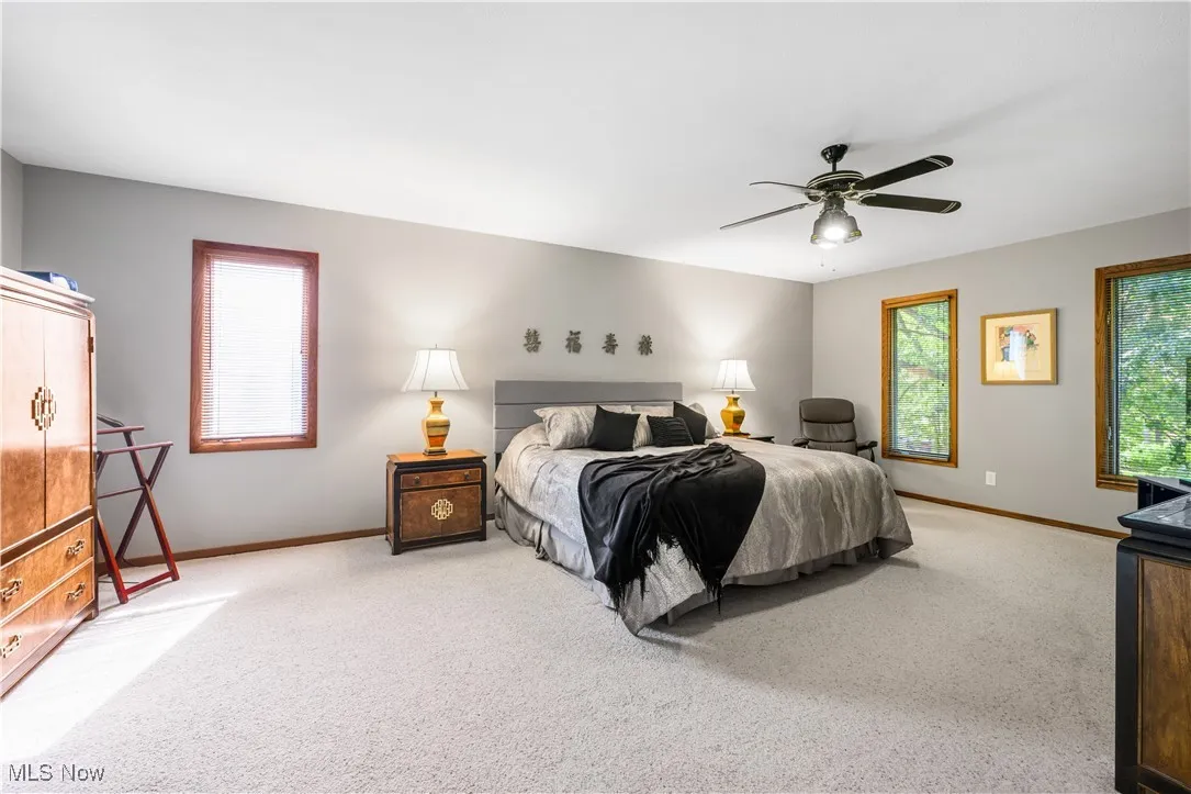 Carpeted bedroom with baseboards and ceiling fan