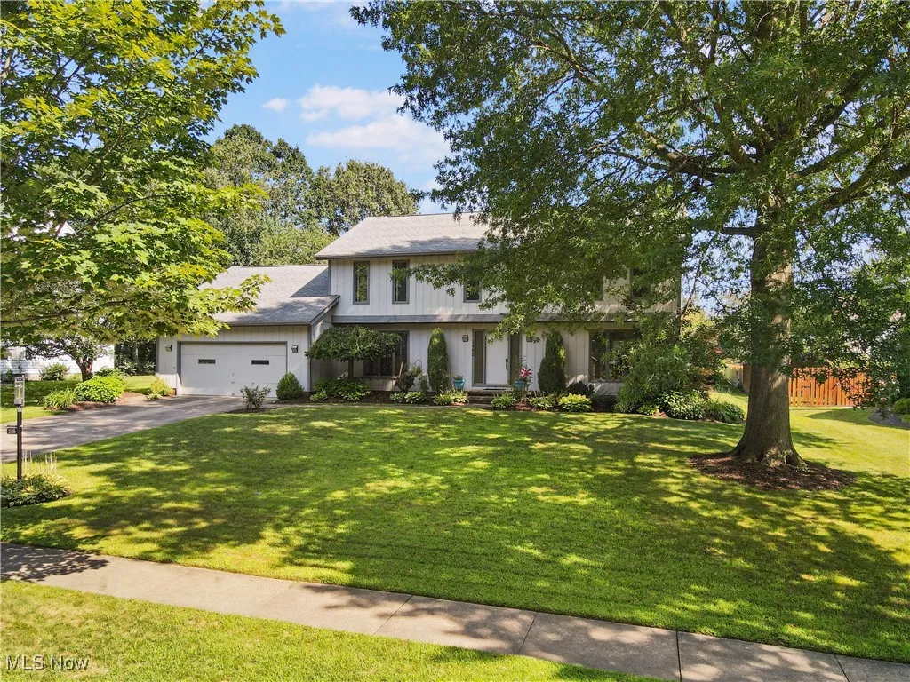 View of front facade featuring driveway, a front yard, and a garage