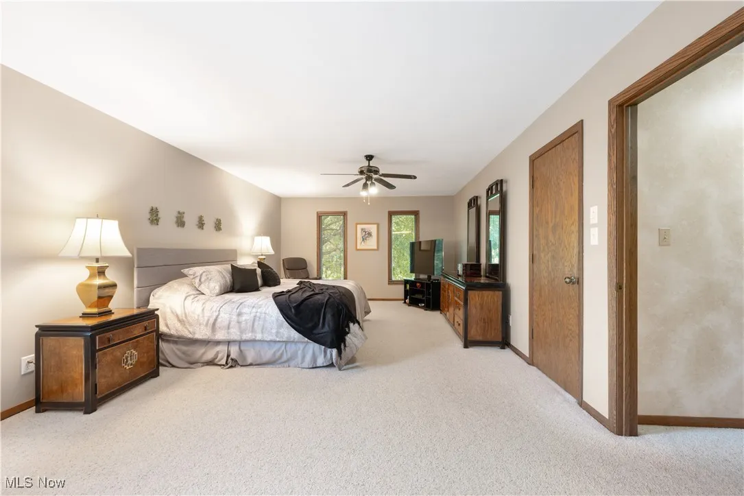 Bedroom with light colored carpet and ceiling fan