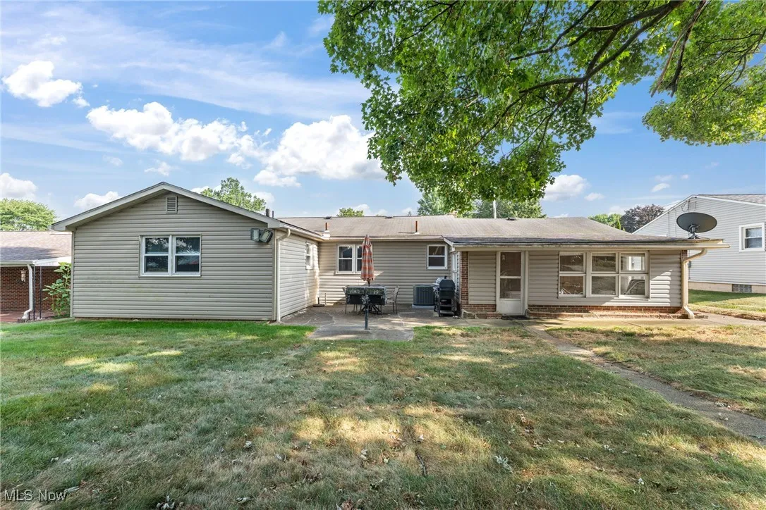 Back of property with a patio and a lawn